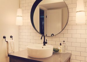 Classic, sophisticated bathroom with subway tile walls, top-mount sink vessel and pendant lights