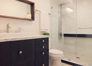 Modern bathroom with walk-in shower, hexagon tile and black vanity